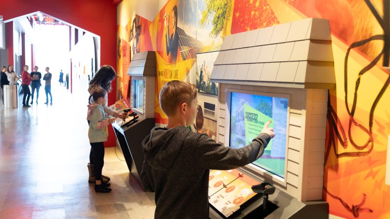 Children use a scanner to play a barcode game about energy efficiency at Holland Energy Park.